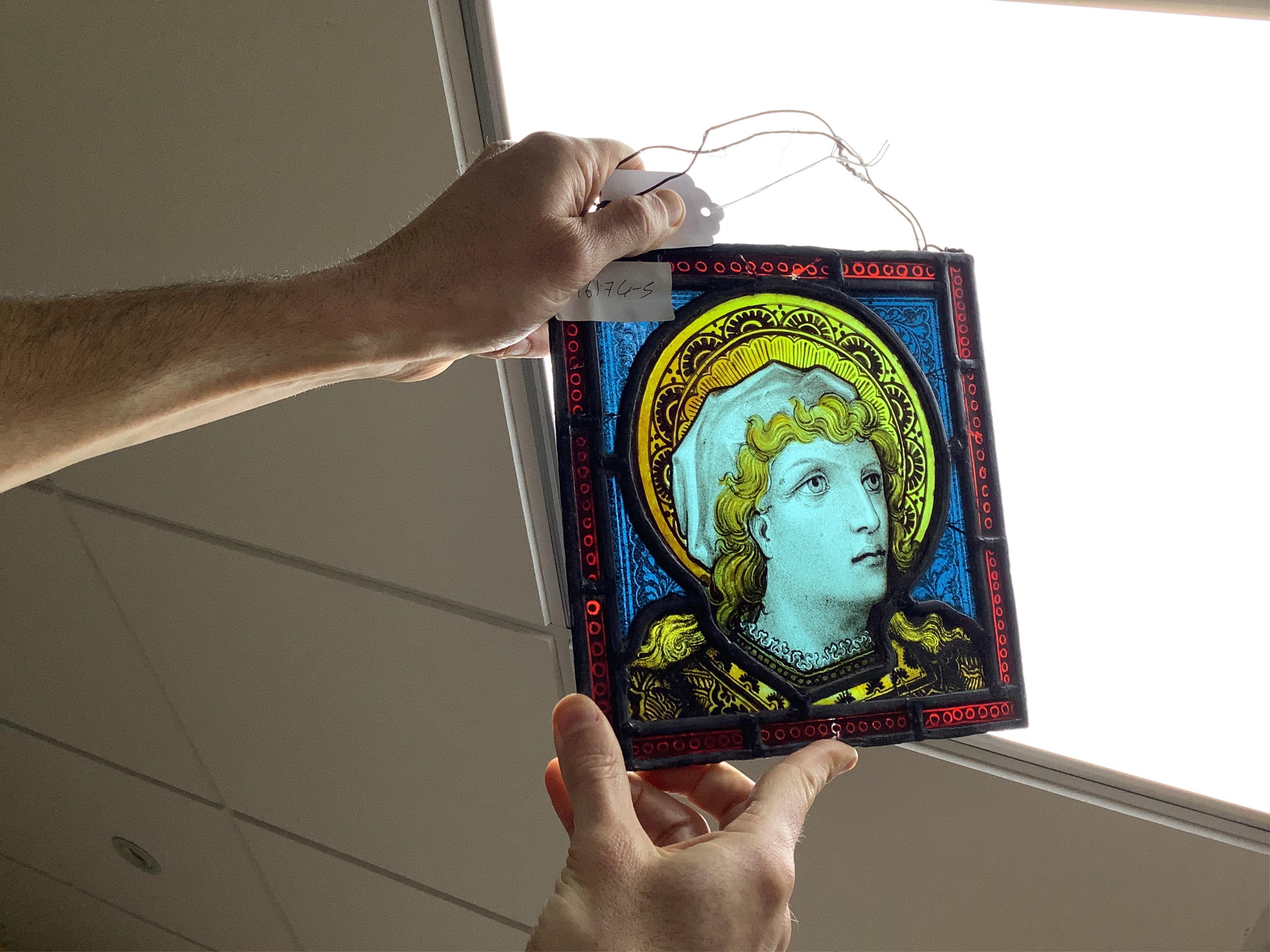 A stained glass panel showing the head of a saint, 21 x 20cm. Condition - four panels cracked